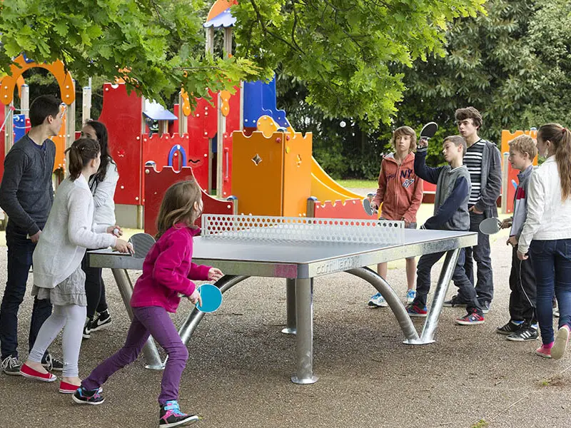 Children playing ping pong in a playground.