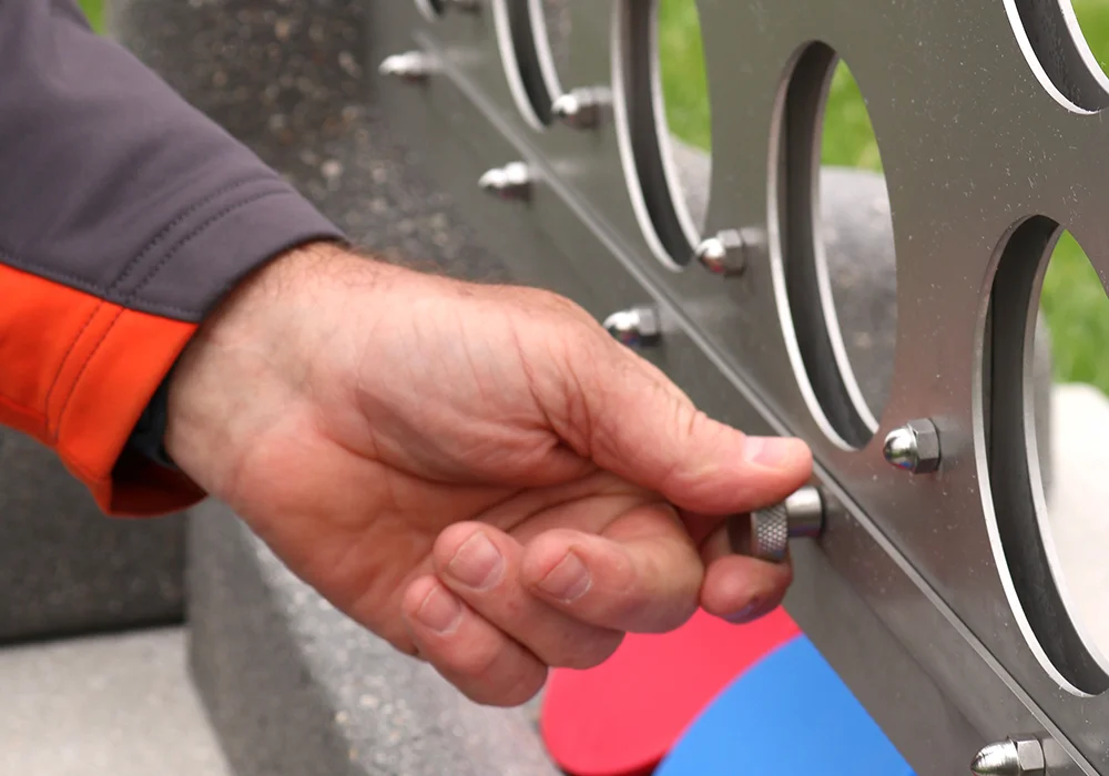 Hand turning a knob on a metal object.