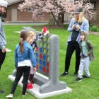 Family playing giant Connect Four in a park.