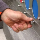 Hand adjusting a knob on a playground structure.