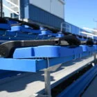 Blue stadium seating with a black handle.