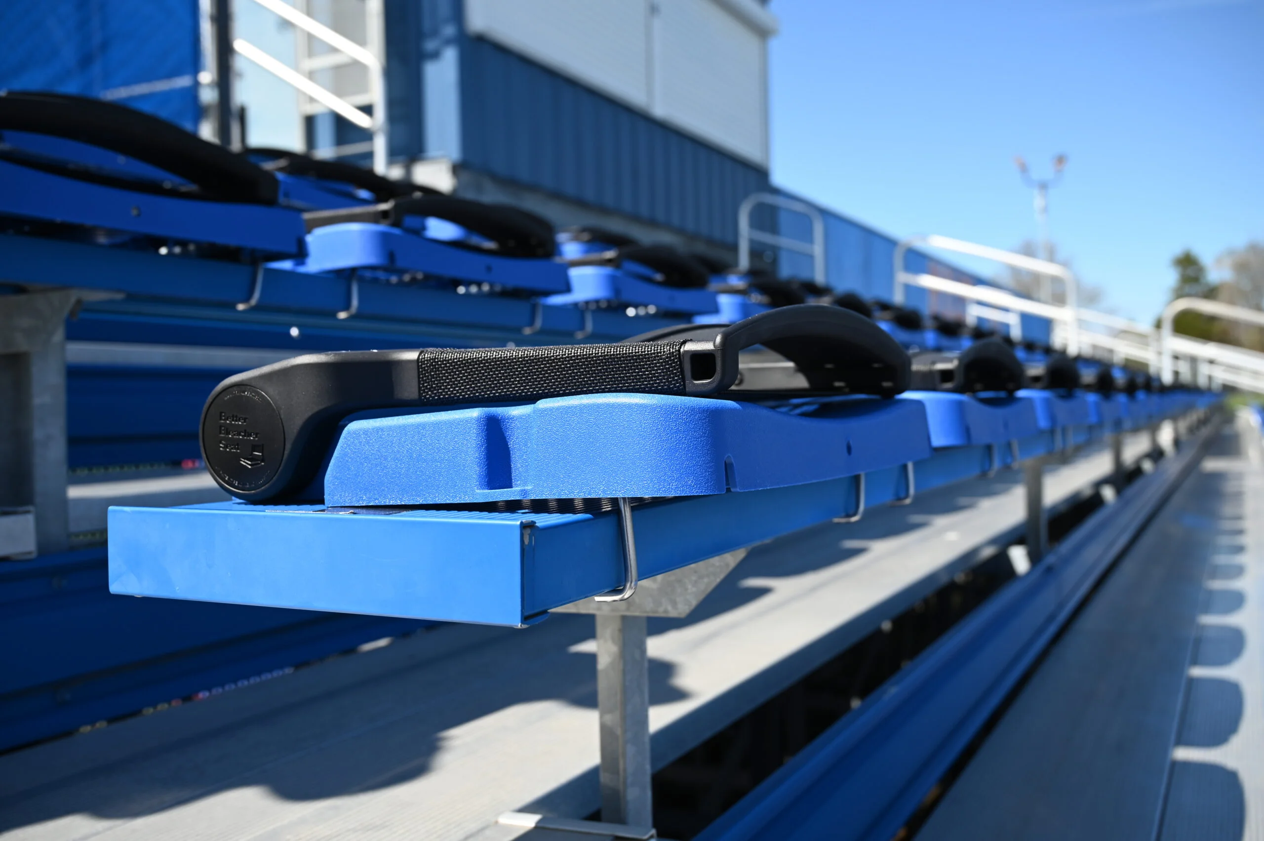 Blue stadium seating with a black handle.