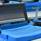 Blue stadium seat with mesh back and footrest.