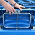 Blue folding chair being adjusted in a stadium.
