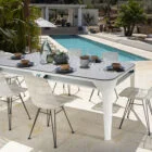 Outdoor dining table and chairs by a pool.