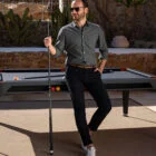 Man playing pool in outdoor setting.