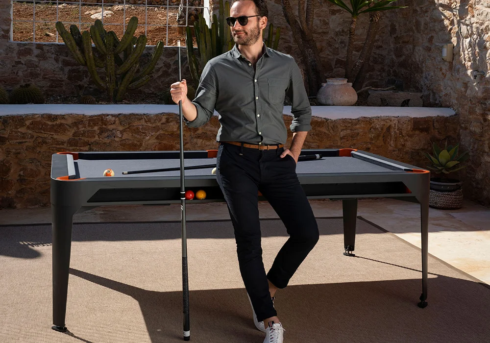 Man playing pool in outdoor setting.