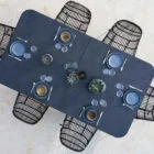 A modern dining table set with blue plates and cutlery on a white surface.