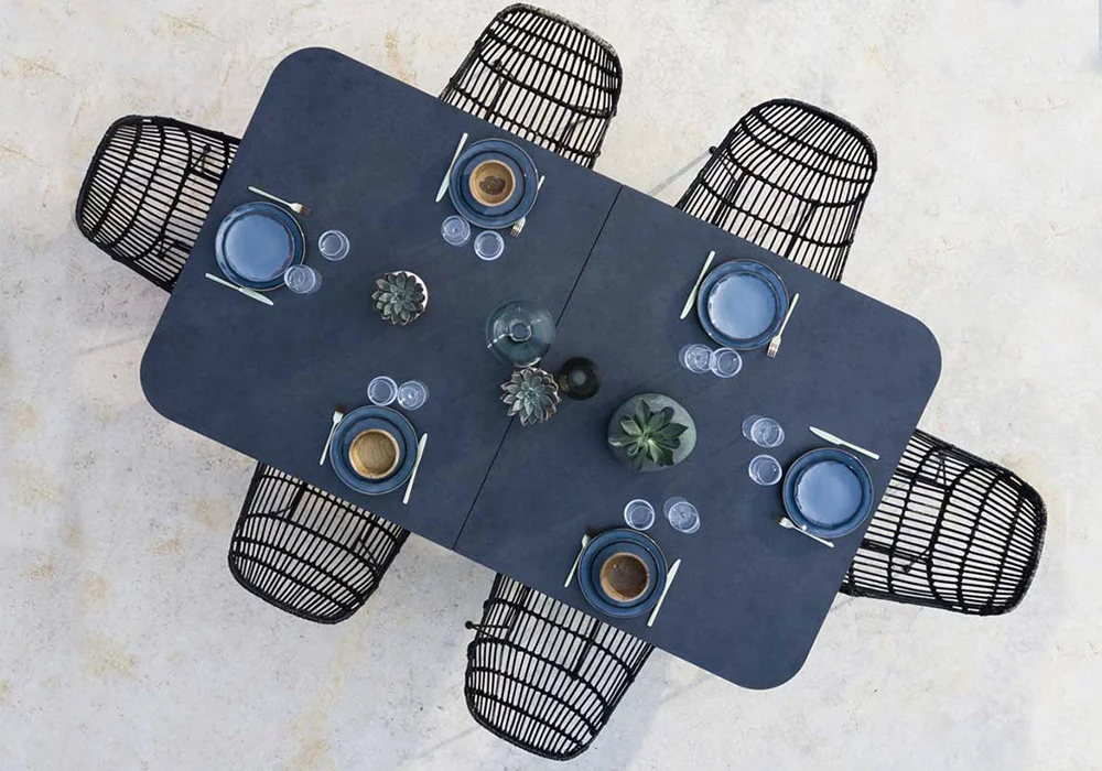 A modern dining table set with blue plates and cutlery on a white surface.