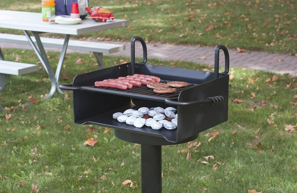 Portable grill on grassy outdoor area.
