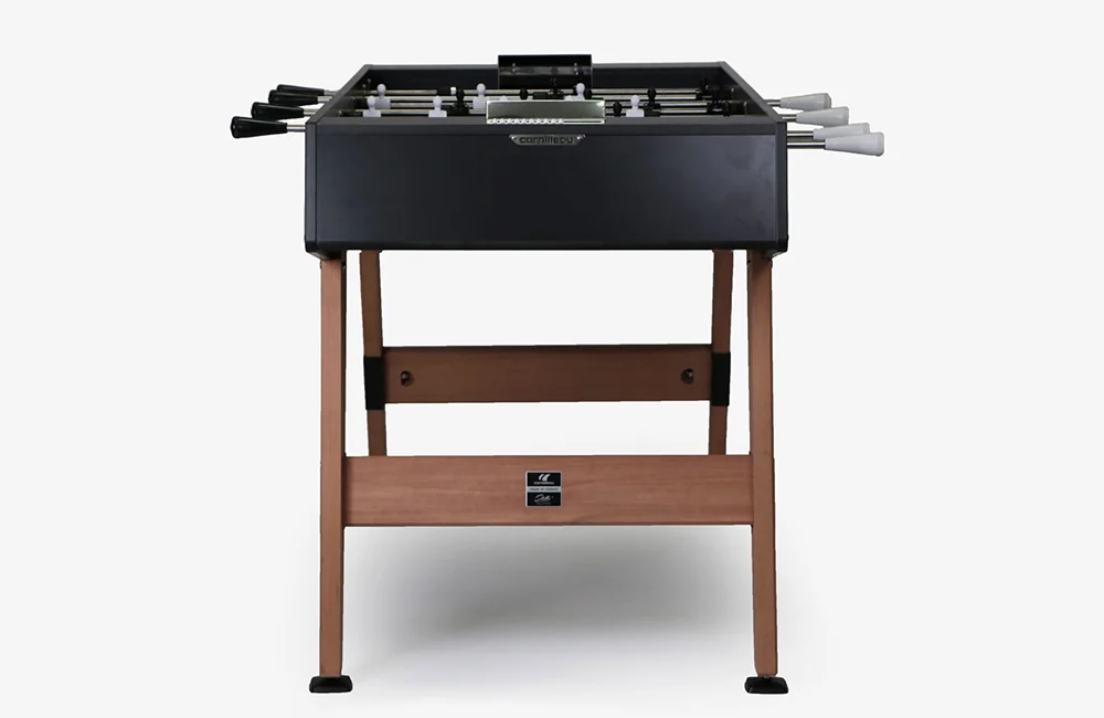 Foosball table with black top and wooden legs.