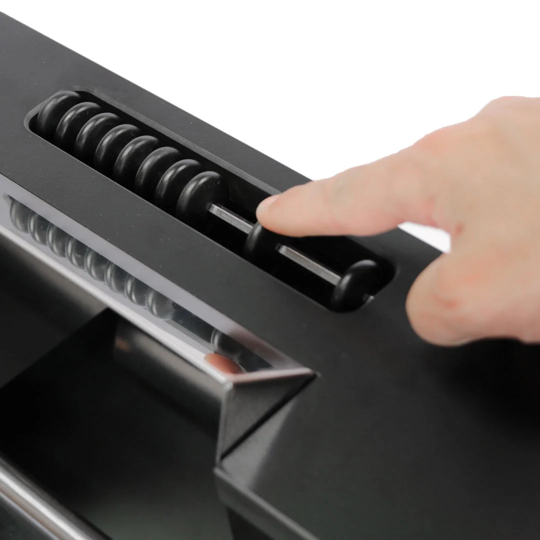 Hand pressing a button on a black electronic device.