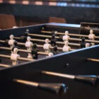 Foosball table with white figures and black rods.