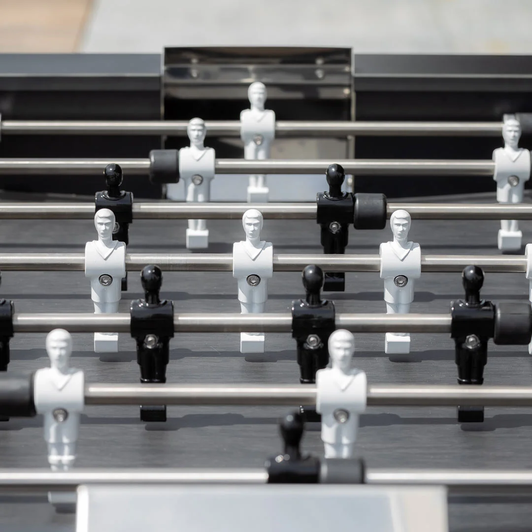 Foosball table with white and black figures.