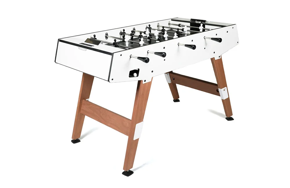 Foosball table with white top and wooden legs.