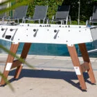 Foosball table by a pool.