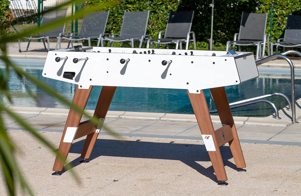 Foosball table by a pool.