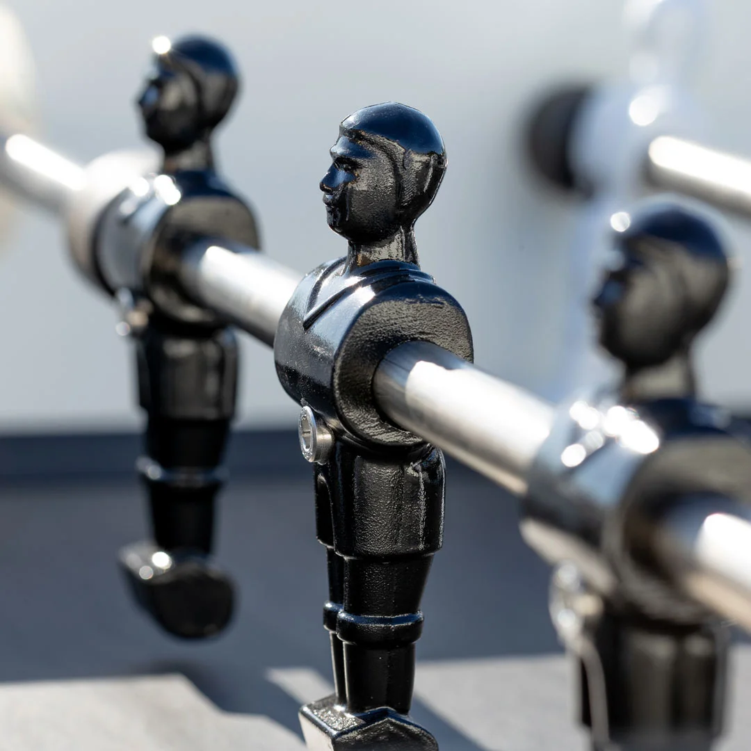 Black metal figurines holding handles in a row.
