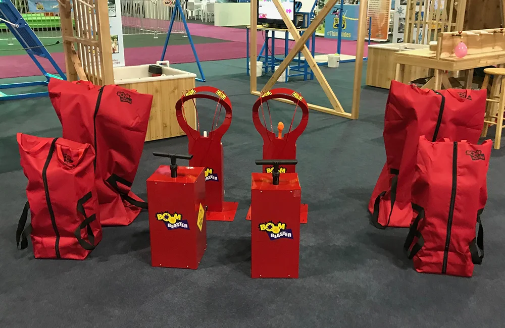 Red toy blasters and bags on a playground.