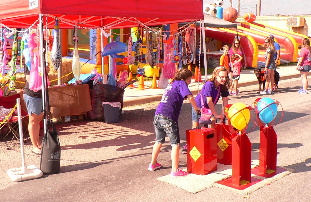 Children playing at an outdoor carnival game.