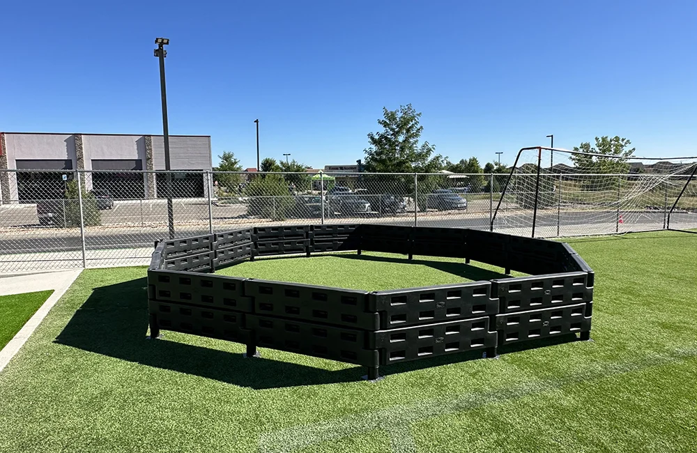 A black plastic structure on a green artificial turf field.