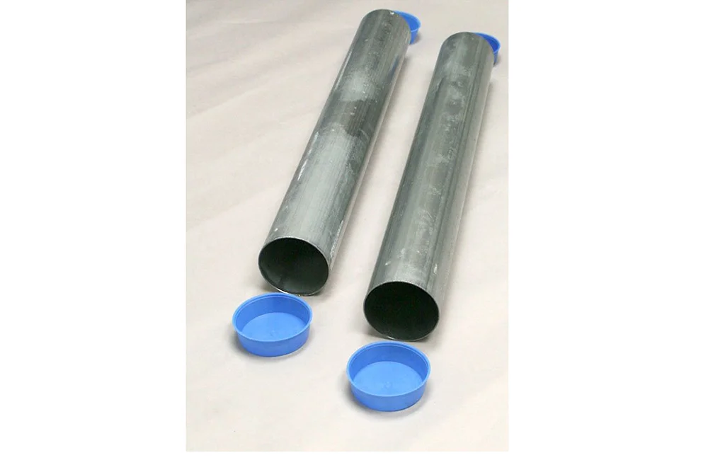 Two metal pipes and two blue caps on a white surface.