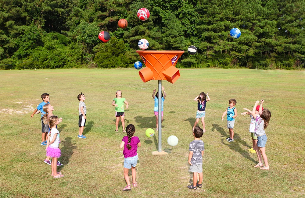 Children playing with colorful balls in a field.