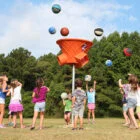 Children playing with colorful balls in a park.