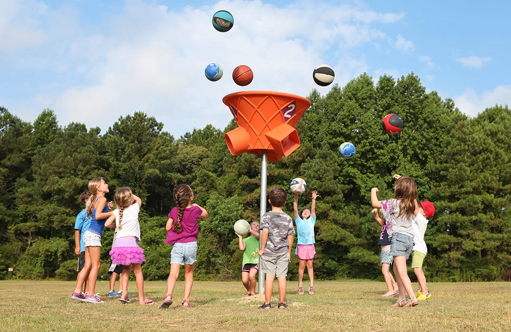 Children playing with colorful balls in a park.