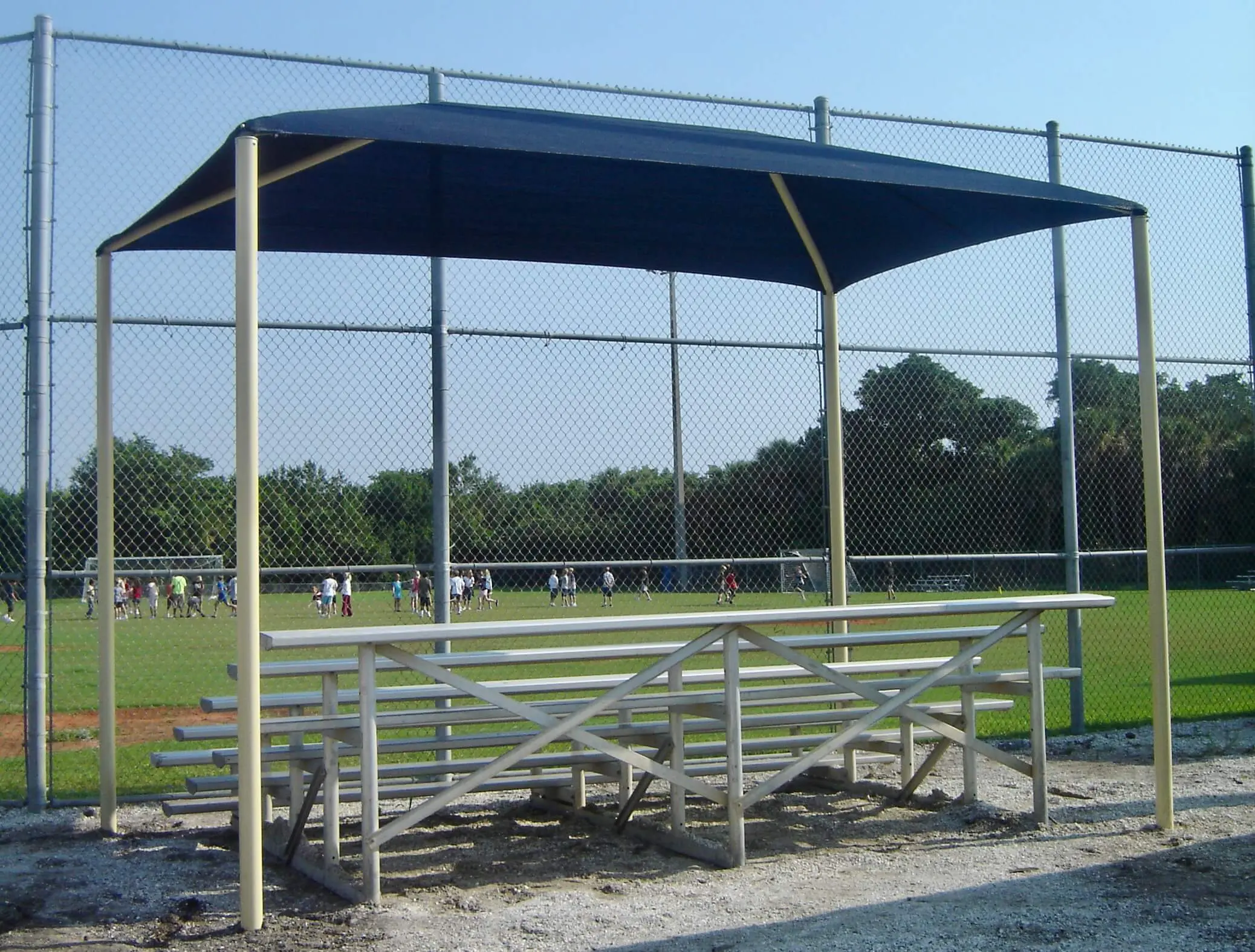 Baseball dugout shelter with benches and awning.