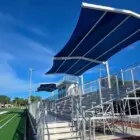 Sports field with bleachers and solar panels.