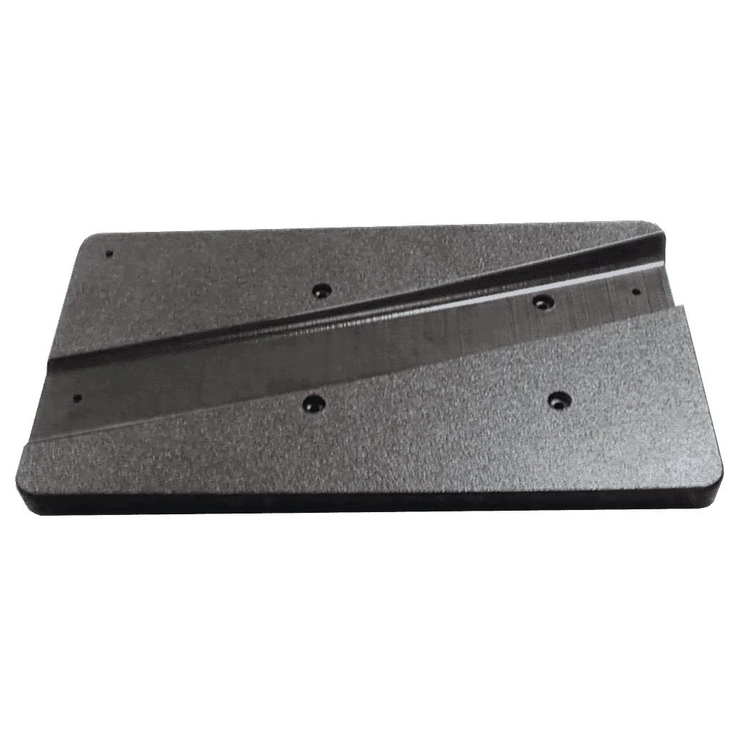 Black rectangular object with holes and a textured surface.