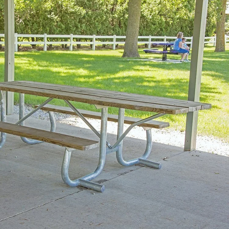 Wooden picnic table in a park setting.