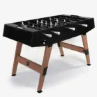 Foosball table with black top and wooden legs.