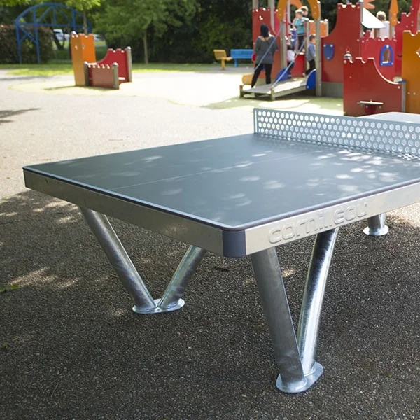 CNPROPONG-1-WEB Outdoor ping pong table in a playground setting.