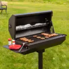 Portable grill on grassy lawn.