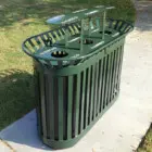 Green metal trash can on a sidewalk.