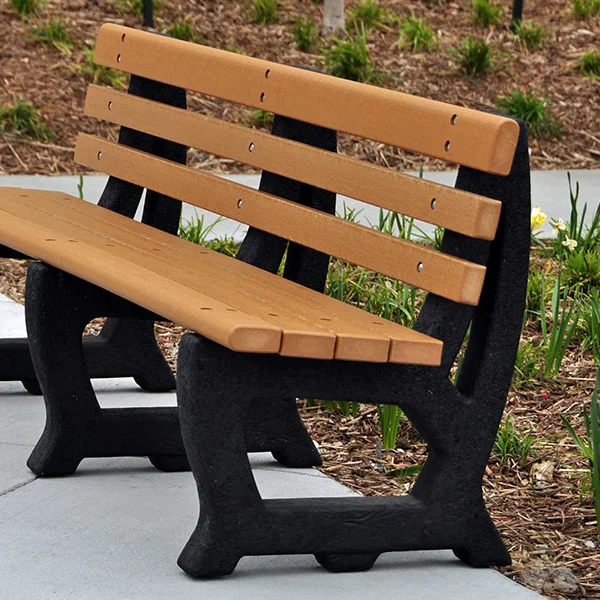JPBR6-WEB-Cedar-scene Wooden bench with black legs and backrest in a garden setting.