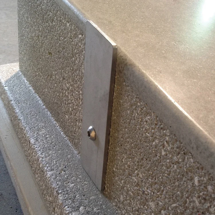 Concrete step with a metal grab bar and a small hole in it.