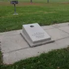 Concrete plaque on sidewalk in park.