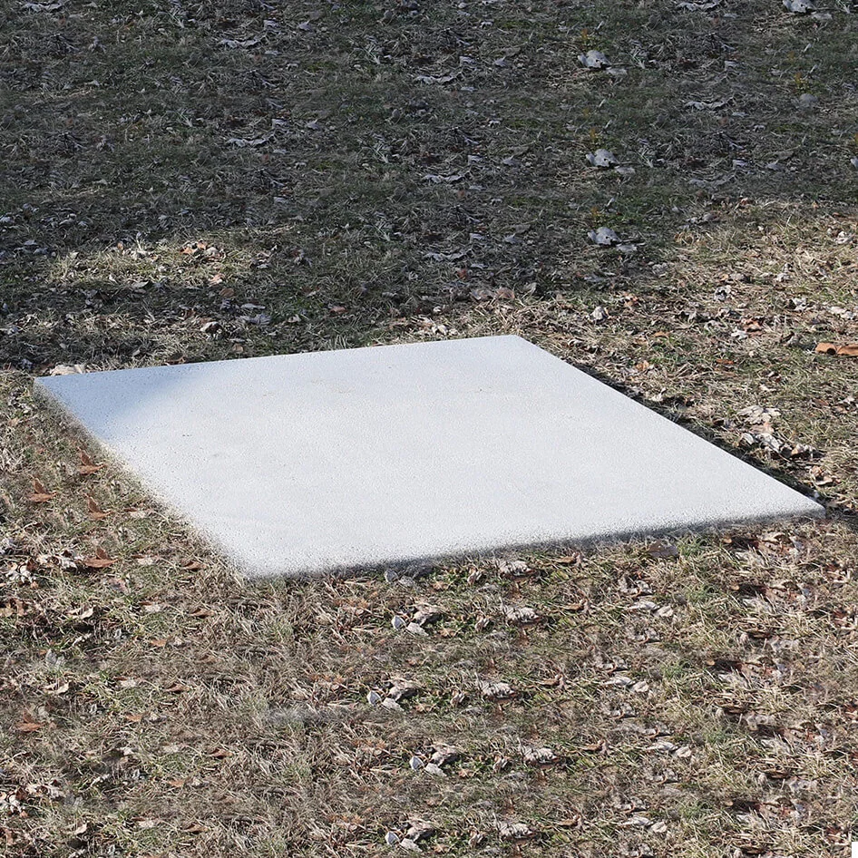 Concrete stepping stone on grassy area.