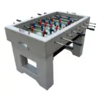 Foosball table with gray surface and red, blue, and black players.