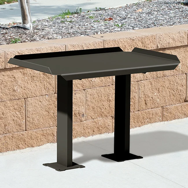 Black metal table on a sidewalk.