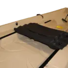 Boat seat with black cover and yellow sticker.
