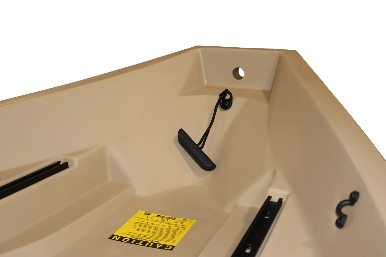 Beige bathtub with black handles and a yellow caution label.