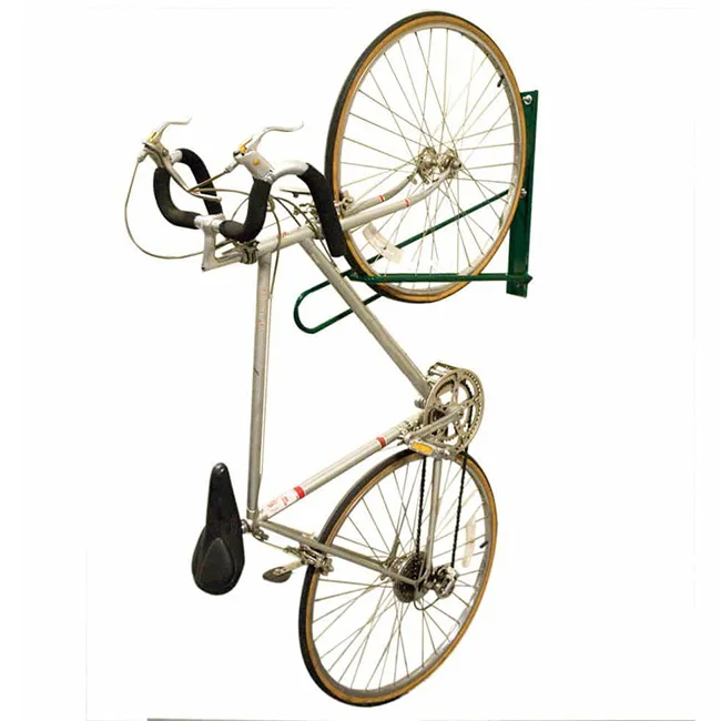 Bicycle mounted on a green wall rack.