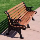 Wooden park bench with black metal armrests and legs.
