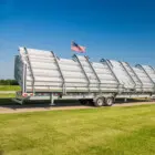 Trailer with American flag on a grassy field.