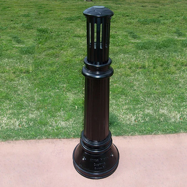 Black bollard light on grassy background.