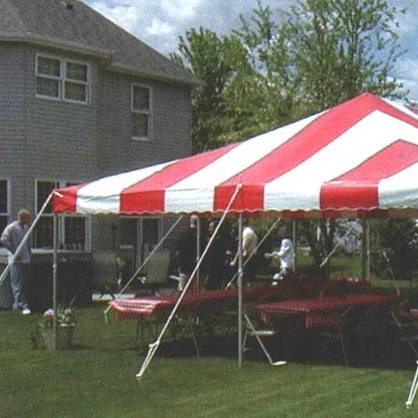 Red and white striped tent on grassy lawn.
